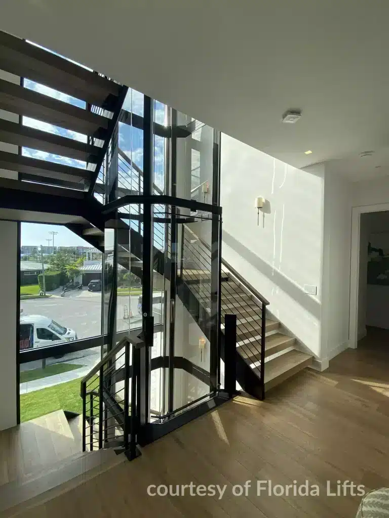 Savaria Vuelift Glass Elevator, Modern interior with a staircase featuring floor-to-ceiling windows.