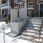 Savaria Multi Lift Installed Outdoor on a Home Next to a Snow Covered Staircase.