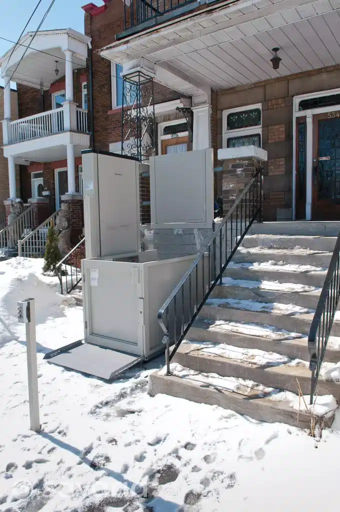 Savaria Multi Lift Installed Outdoor on a Home Next to a Snow Covered Staircase.