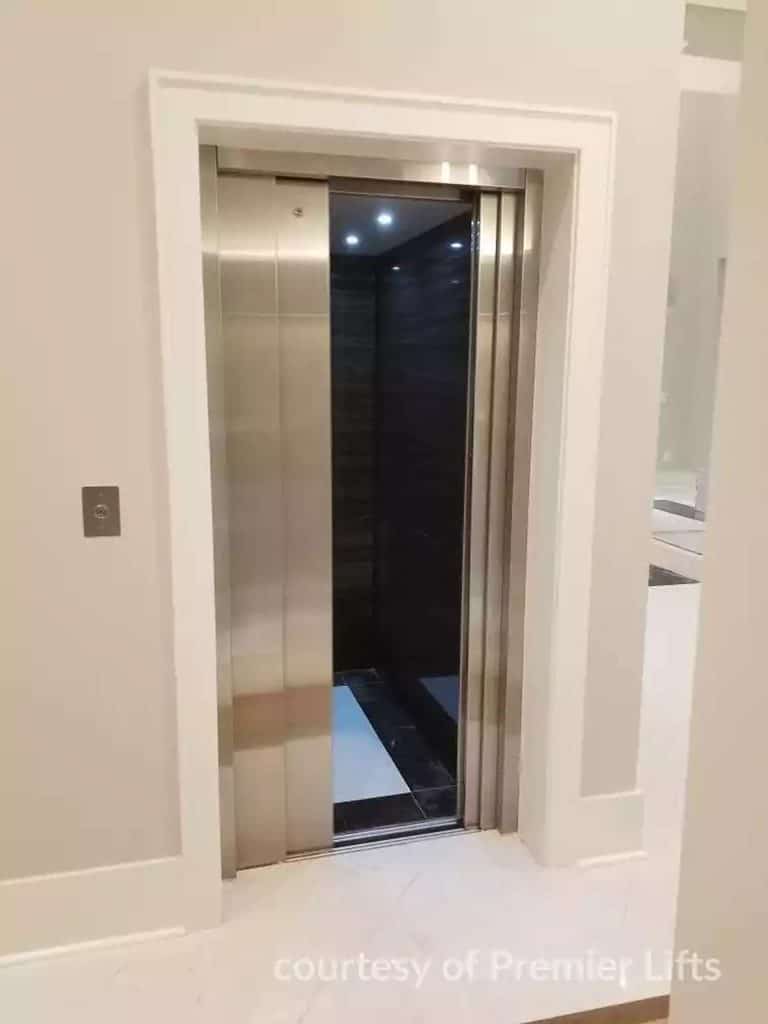 Partially Open Savaria Eclipse Home Elevator Stainless Steel Doors and Dark Interior.