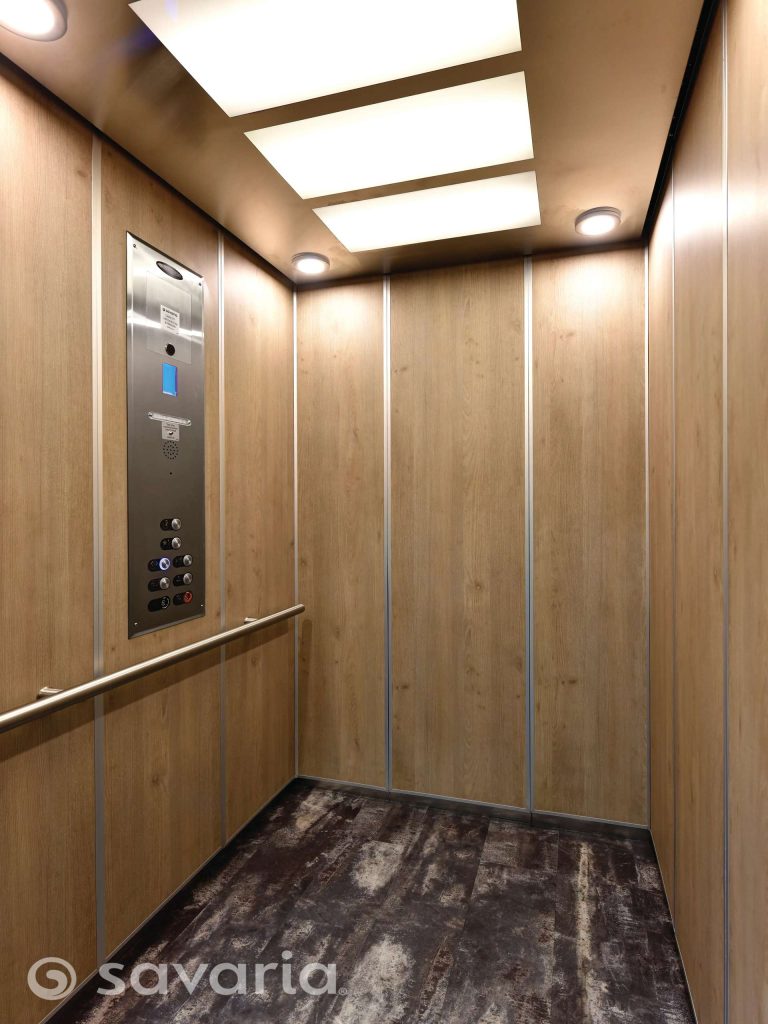 Savaria Orion17 Commercial Modern Elevator with Wooden Panels and a Metallic Control Panel.