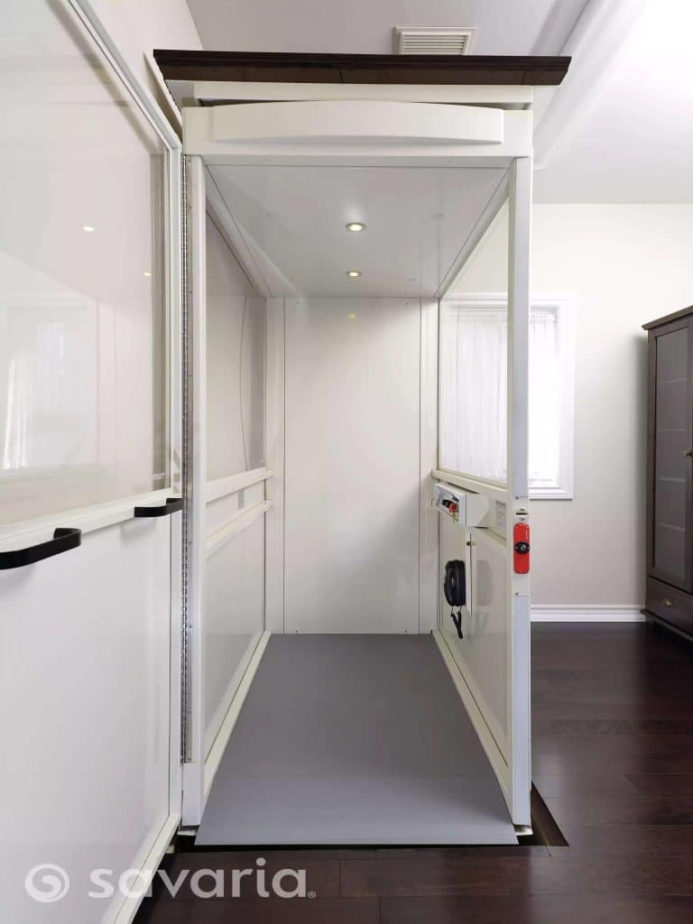 Interior View of a Savaria Telecab Home Lift With White Walls on Dark Floor.