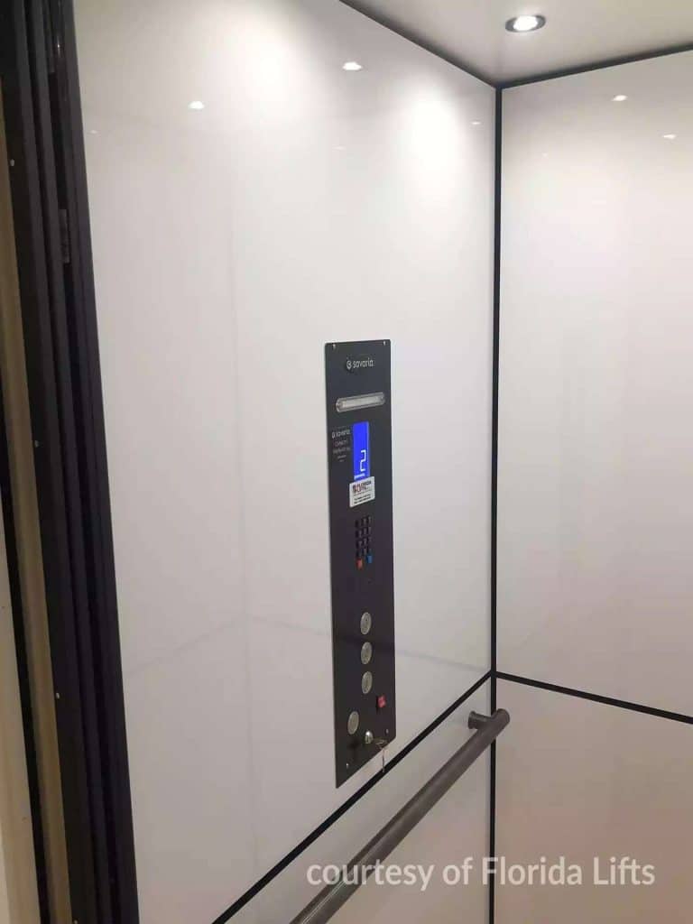 Interior of a Modern Savaria Elevator with Sleek White Walls With Control panel and handrail.