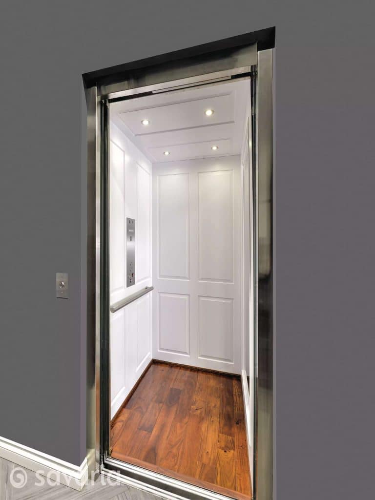 Savaria MDF Material Modern Home Elevator with white paneled walls, recessed lights, wooden floor, and a metallic control panel. Exterior has a gray wall with button panel.