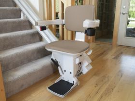 Bruno Elite curved indoor stair lift on a curved staircase, showcasing its color options, comfortable seat, and sleek design.